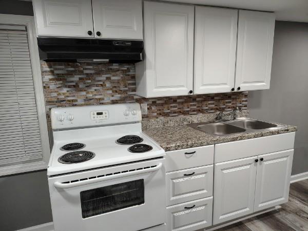 1113 35th Street Columbus, GA 31904 - Photo 4 of 9 a kitchen with white cabinets and appliances