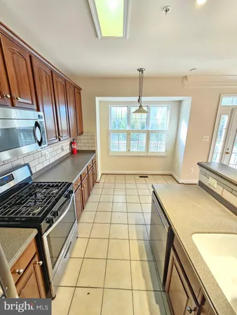 a kitchen with a stove a sink a refrigerator and wooden floor