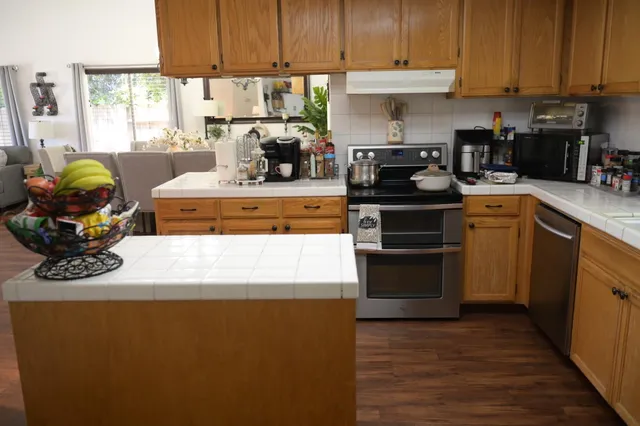 a kitchen with stainless steel appliances granite countertop a stove a refrigerator and a sink