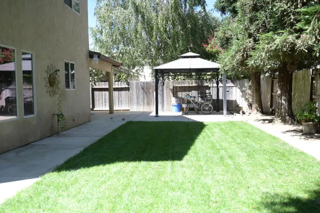 a view of a house with backyard and sitting area