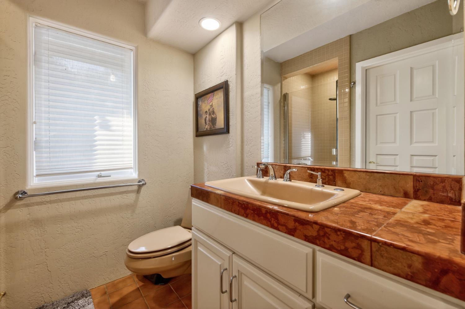 7570 Airola Road Vallecito, CA 95251 - Photo 53 of 90 a bathroom with a granite countertop sink mirror vanity and toilet