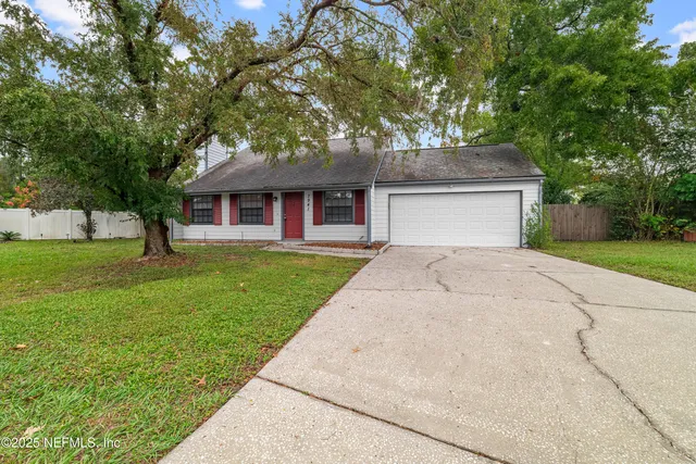 a front view of a house with a yard and trees