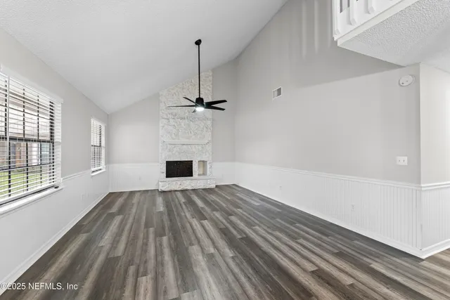 a view of empty room with wooden floor and window