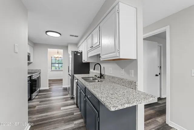 a kitchen with kitchen island granite countertop a stove and a sink