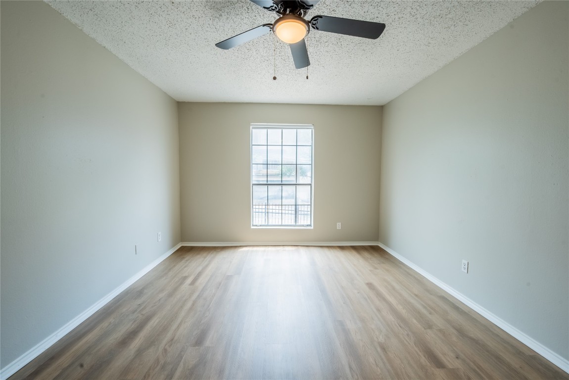 2401 Leon Street, Unit 108 Austin, TX 78705 - Photo 11 of 13 wooden floor in an empty room with a window