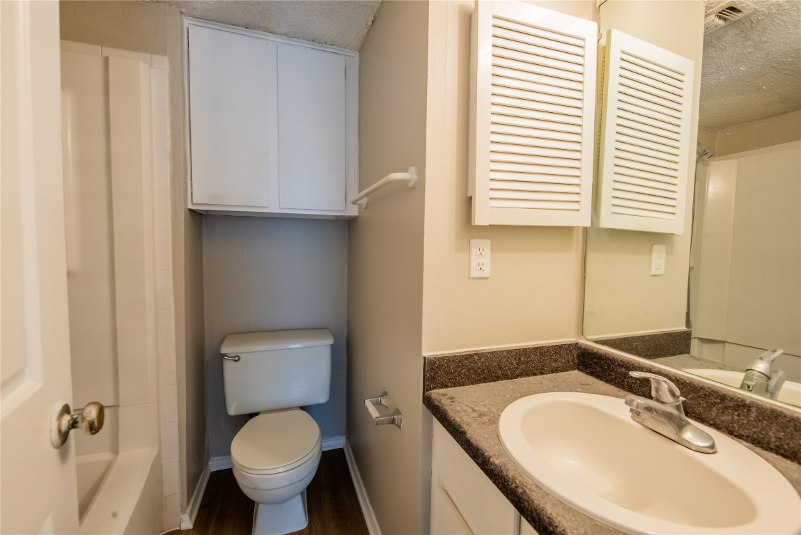 2401 Leon Street, Unit 108 Austin, TX 78705 - Photo 13 of 13 a bathroom with a granite countertop toilet and a sink