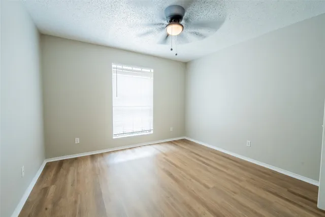 an empty room with a window and wooden floor