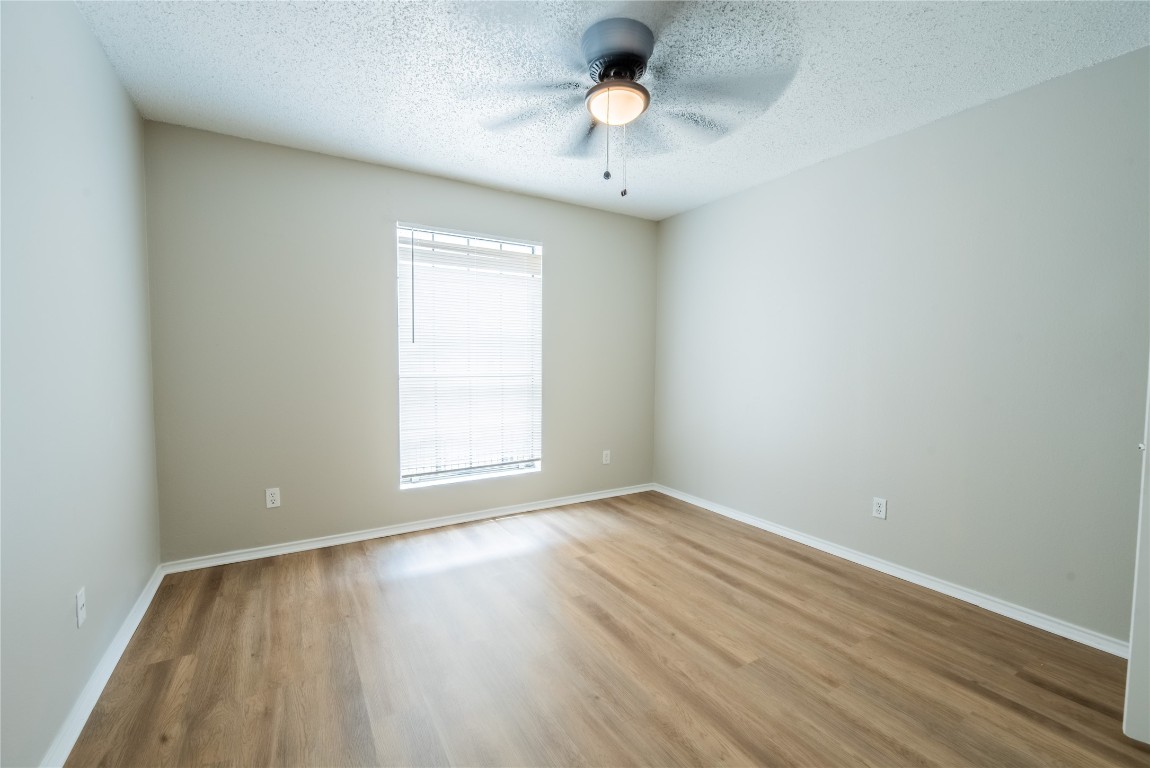 2401 Leon Street, Unit 108 Austin, TX 78705 - Photo 7 of 13 an empty room with a window and wooden floor