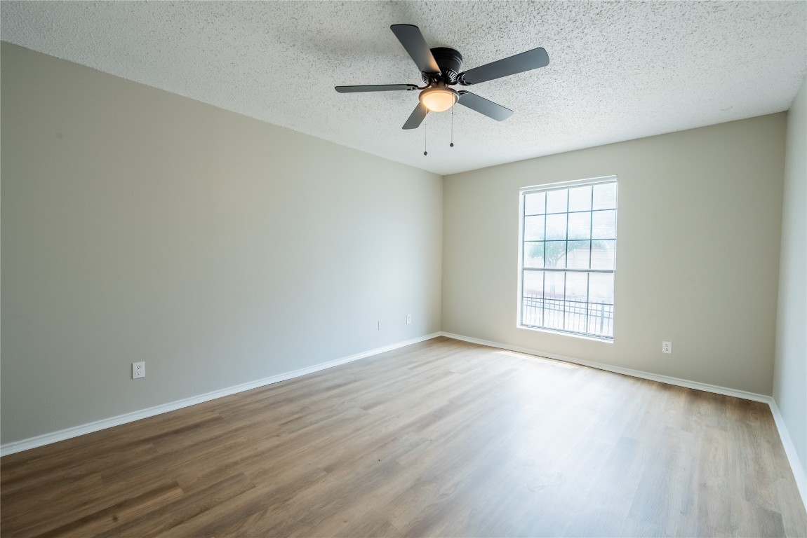 2401 Leon Street, Unit 108 Austin, TX 78705 - Photo 10 of 13 an empty room with wooden floor and windows