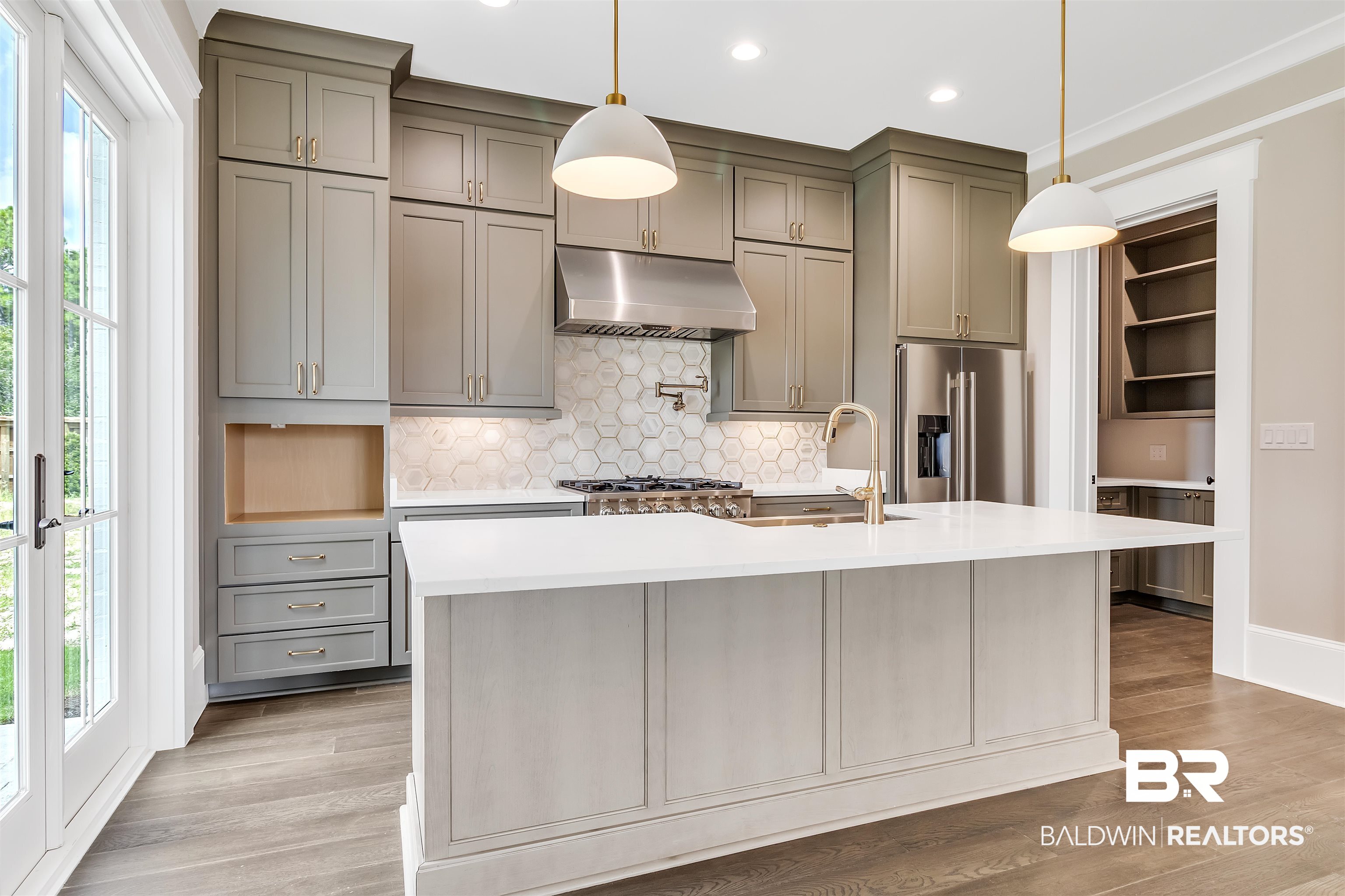 829 Inlet Circle Gulf Shores, AL 36542 - Photo 4 of 31 Kitchen featuring a kitchen island with sink, ventilation hood, high end fridge, and a healthy amount of sunlight