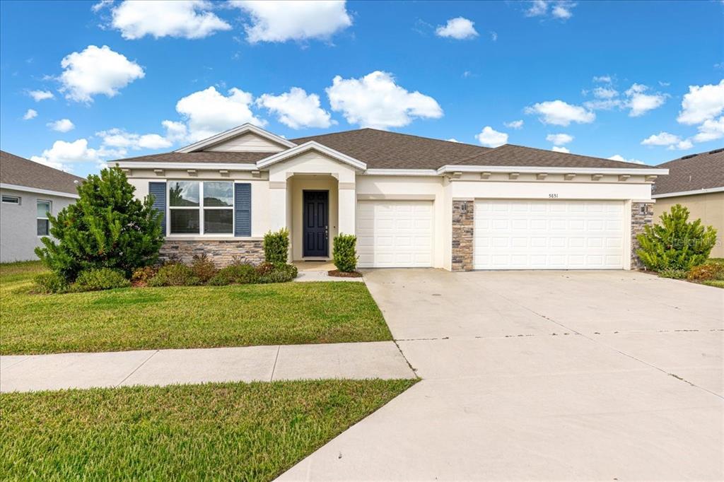 5851 Southwest 85th Place Ocala, FL 34476 - Photo 1 of 57 a front view of a house with a garden and yard