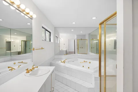 a bathroom with a bathtub shower sink and mirror