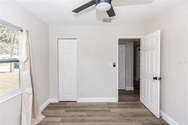 a view of a hallway with wooden floor and windows