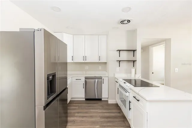 a kitchen with white cabinets and stainless steel appliances