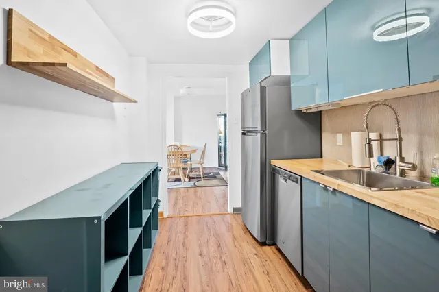 a kitchen with a sink a refrigerator and wooden floor