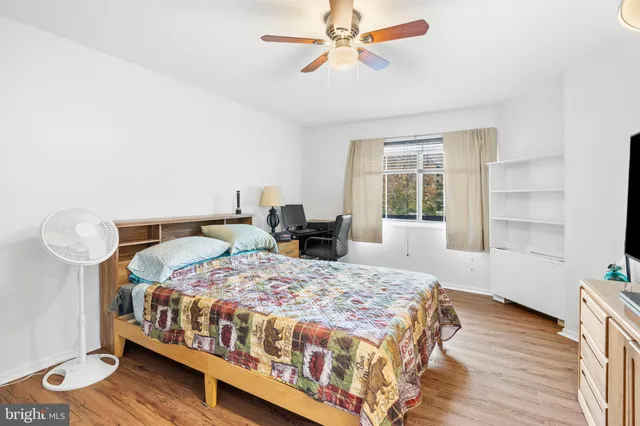 a bedroom with a bed a window and potted plant