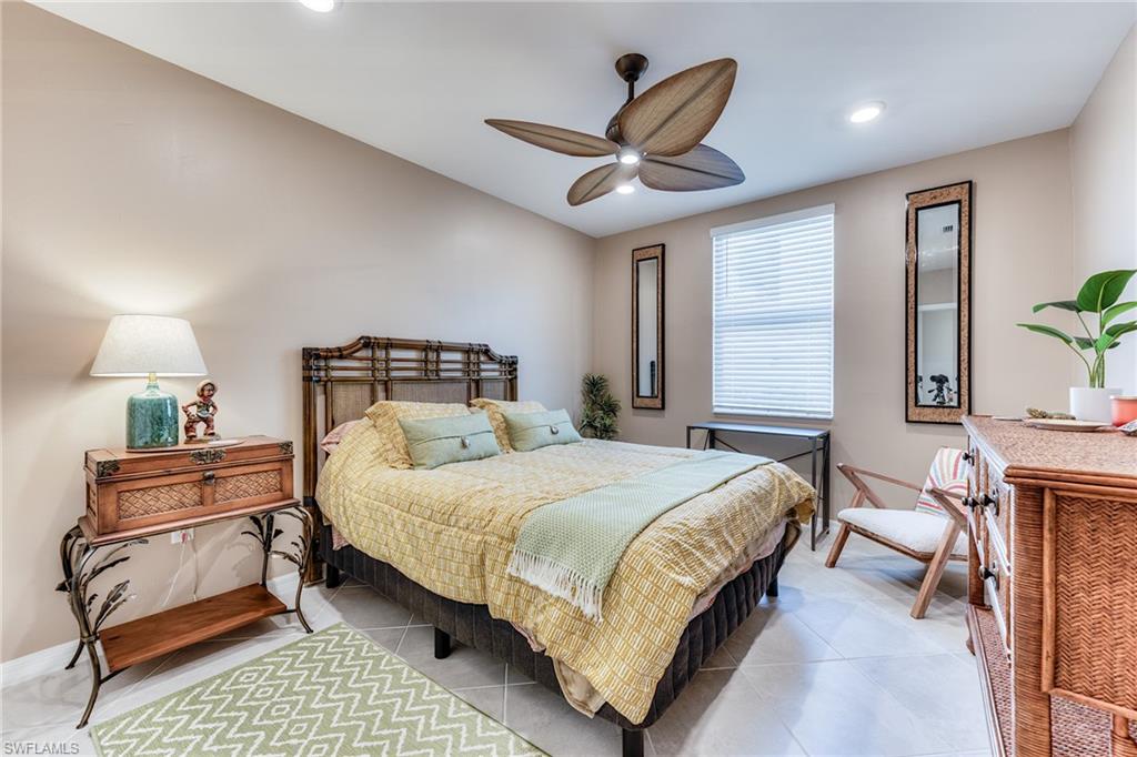 3790 Pebblebrook Ridge Court, Unit 101 Fort Myers, FL 33905 - Photo 21 of 38 a bedroom with a bed and a chandelier
