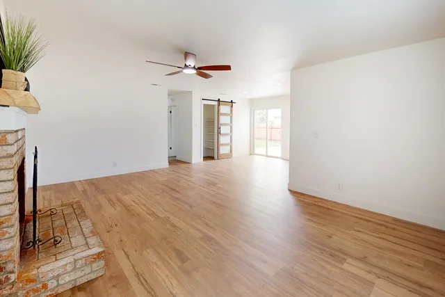 a view of a livingroom with wooden floor and a ceiling fan