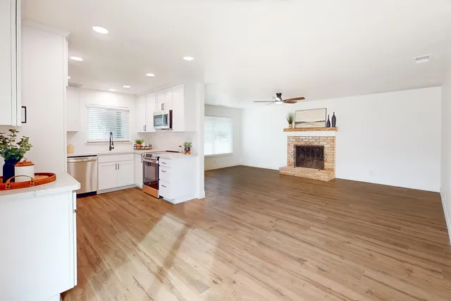 a view of a kitchen with a sink stove cabinets and empty room