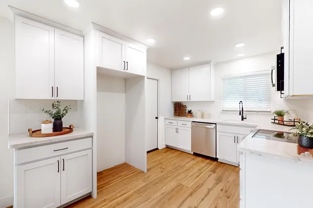 a kitchen with white cabinets and white appliances