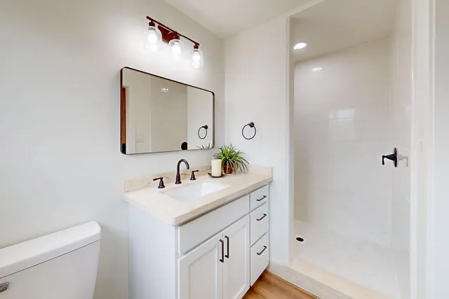 a bathroom with a sink a toilet and shower
