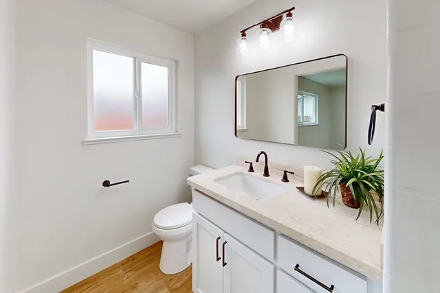a bathroom with a toilet a sink and mirror