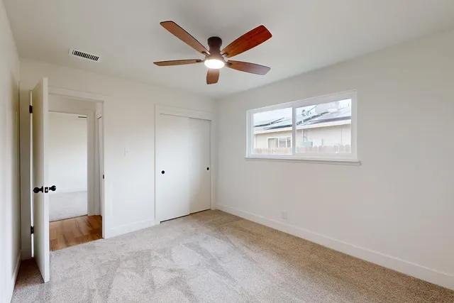 a view of a livingroom with a ceiling fan and window