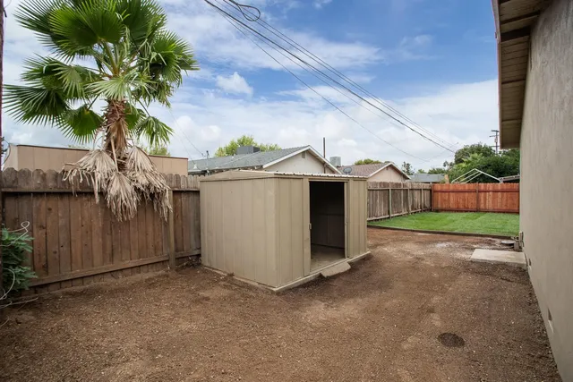 a view of a yard with wooden fence
