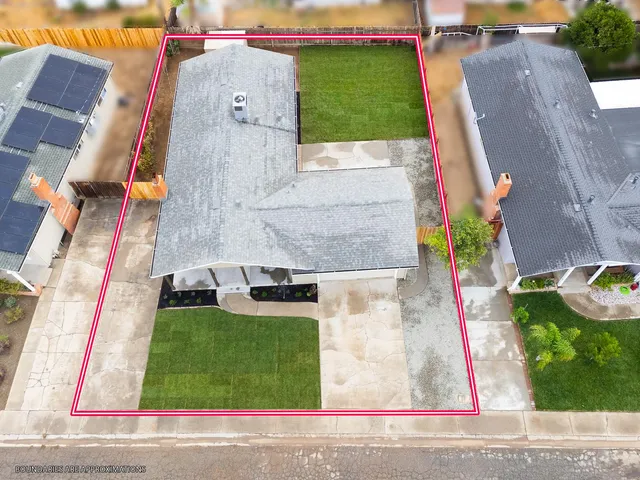 an aerial view of a house with a yard and potted plants