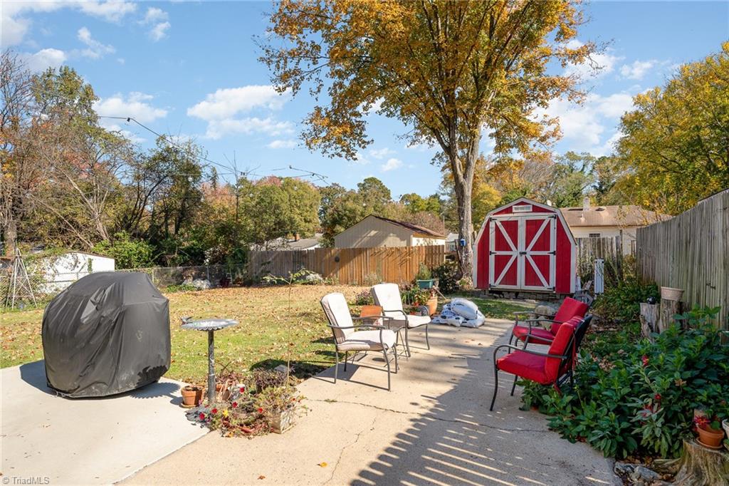 722 Forrest Street High Point, NC 27262 - Photo 8 of 28 backyard with concrete extended drive, concrete patio off back door and large fenced-in yard with storage shed