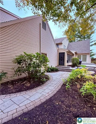 a kitchen with granite countertop a stove a sink a dining table and chairs with wooden floor