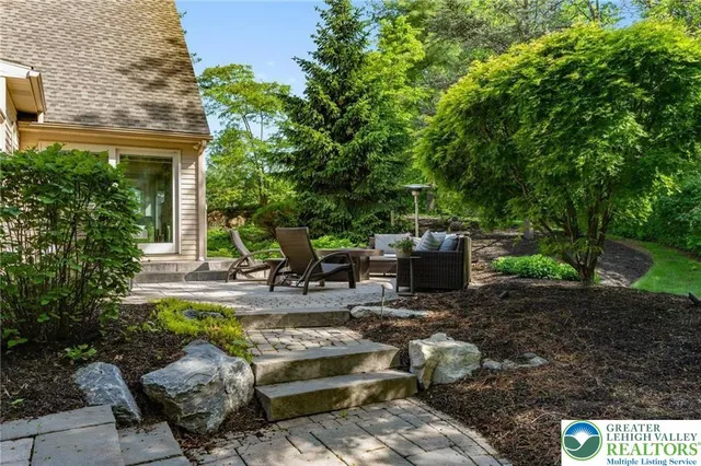 a kitchen with stainless steel appliances granite countertop a stove top oven a sink a dining table and chairs