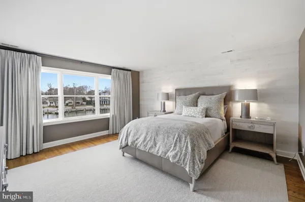 a spacious bedroom with a bed lamp and a large window