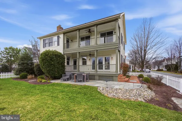 a front view of a house with garden and trees