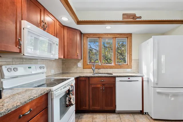 a kitchen with stainless steel appliances granite countertop a sink and a refrigerator