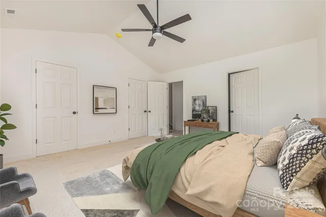 a spacious bedroom with a bed and a chandelier