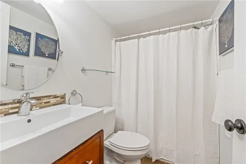 a bathroom with a sink a toilet and shower curtain