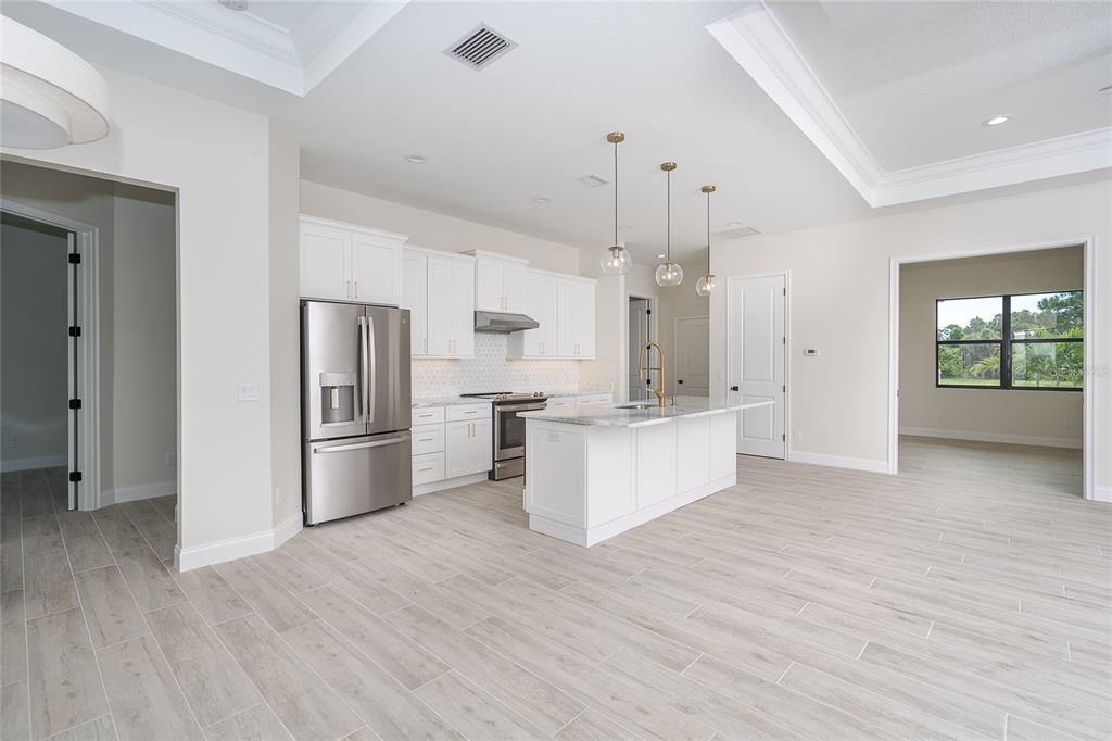191 Tournament Road Rotonda West, FL 33947 - Photo 21 of 41 a large kitchen with kitchen island white cabinets and stainless steel appliances