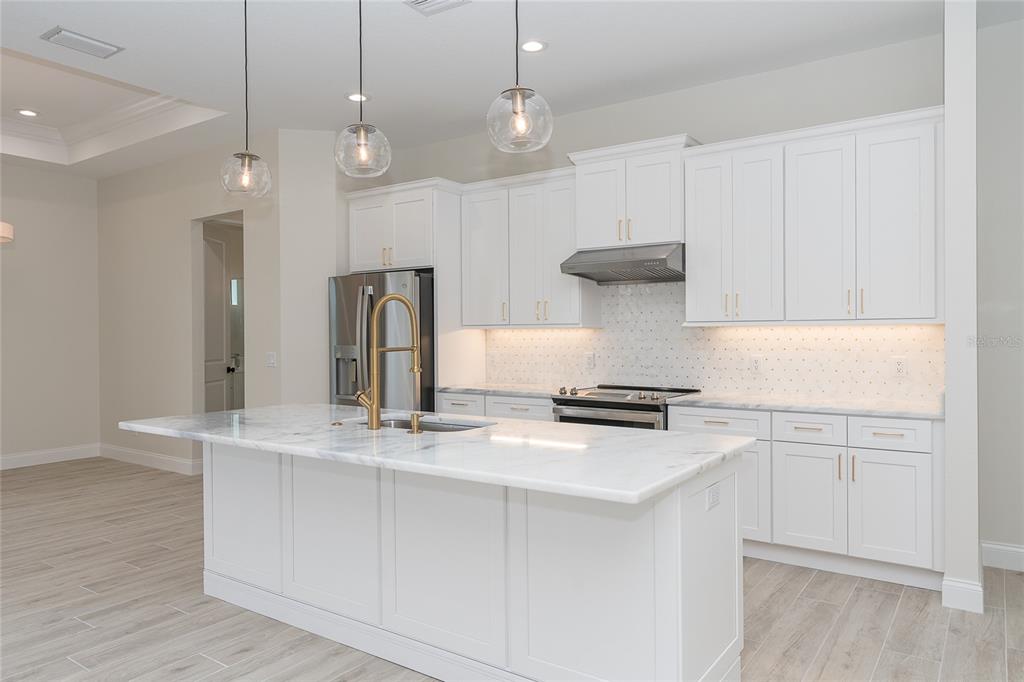 191 Tournament Road Rotonda West, FL 33947 - Photo 22 of 41 a kitchen with kitchen island a stove a sink and a refrigerator
