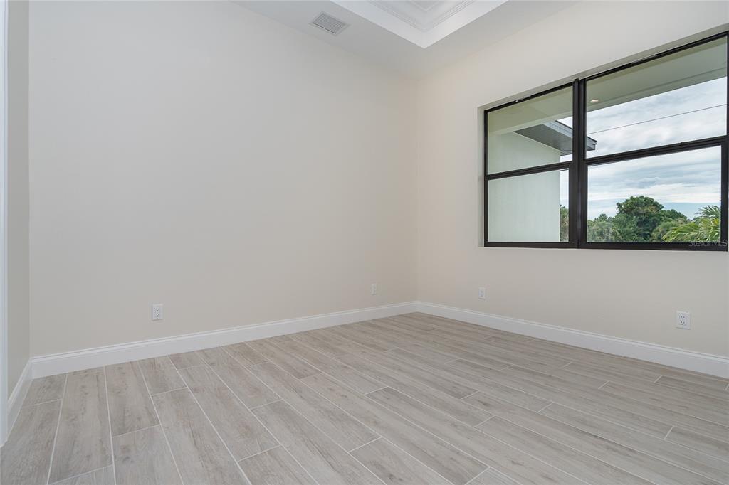 191 Tournament Road Rotonda West, FL 33947 - Photo 25 of 41 wooden floor in an empty room with a window
