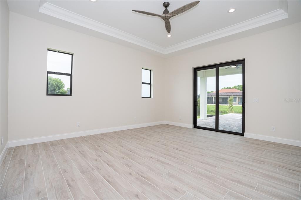 191 Tournament Road Rotonda West, FL 33947 - Photo 27 of 41 a view of an empty room with a window and wooden floor