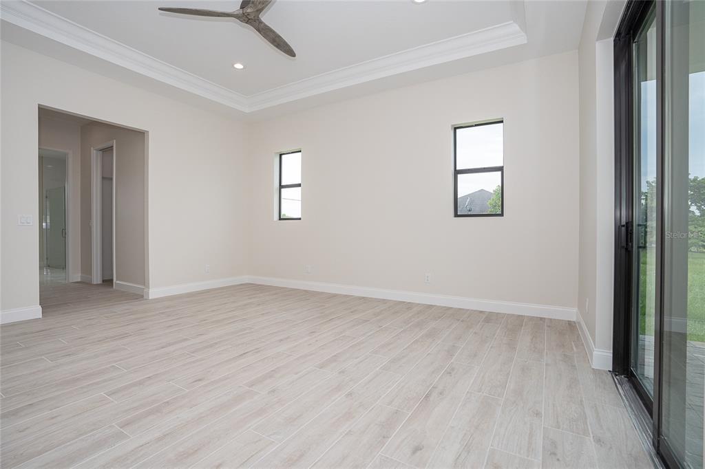 191 Tournament Road Rotonda West, FL 33947 - Photo 28 of 41 an empty room with wooden floor and windows