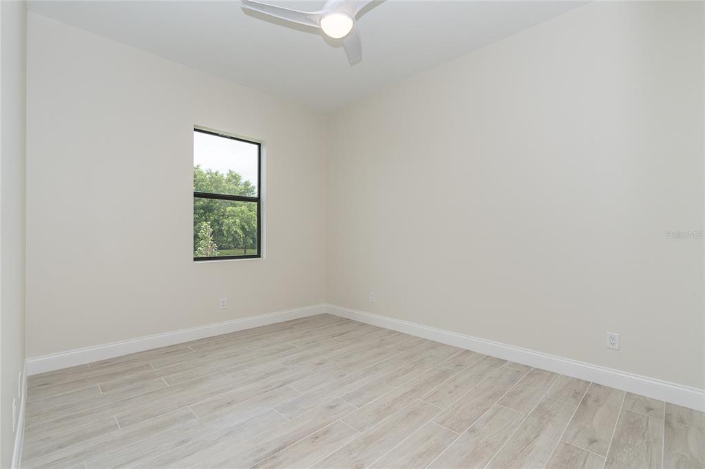 191 Tournament Road Rotonda West, FL 33947 - Photo 32 of 41 an empty room with wooden floor and windows