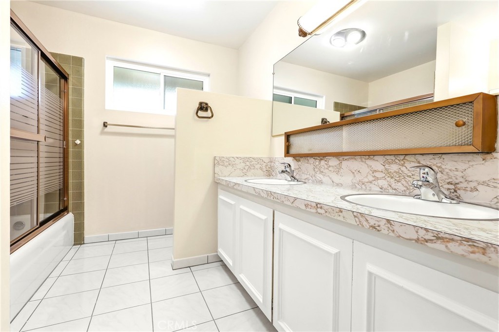 2145 Fairview Avenue Riverside, CA 92506 - Photo 20 of 35 a bathroom with a granite countertop sink a mirror and a shower