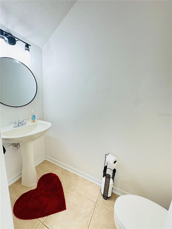 3660 Wilshire Way Road, Unit 260 Orlando, FL 32829 - Photo 10 of 25 a bathroom with a toilet sink and mirror