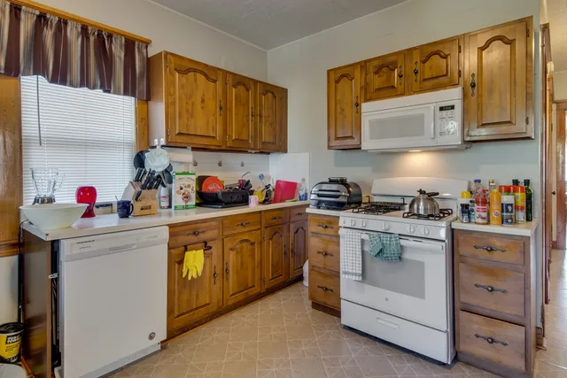 a kitchen with stainless steel appliances granite countertop a sink dishwasher stove and cabinets with wooden floor