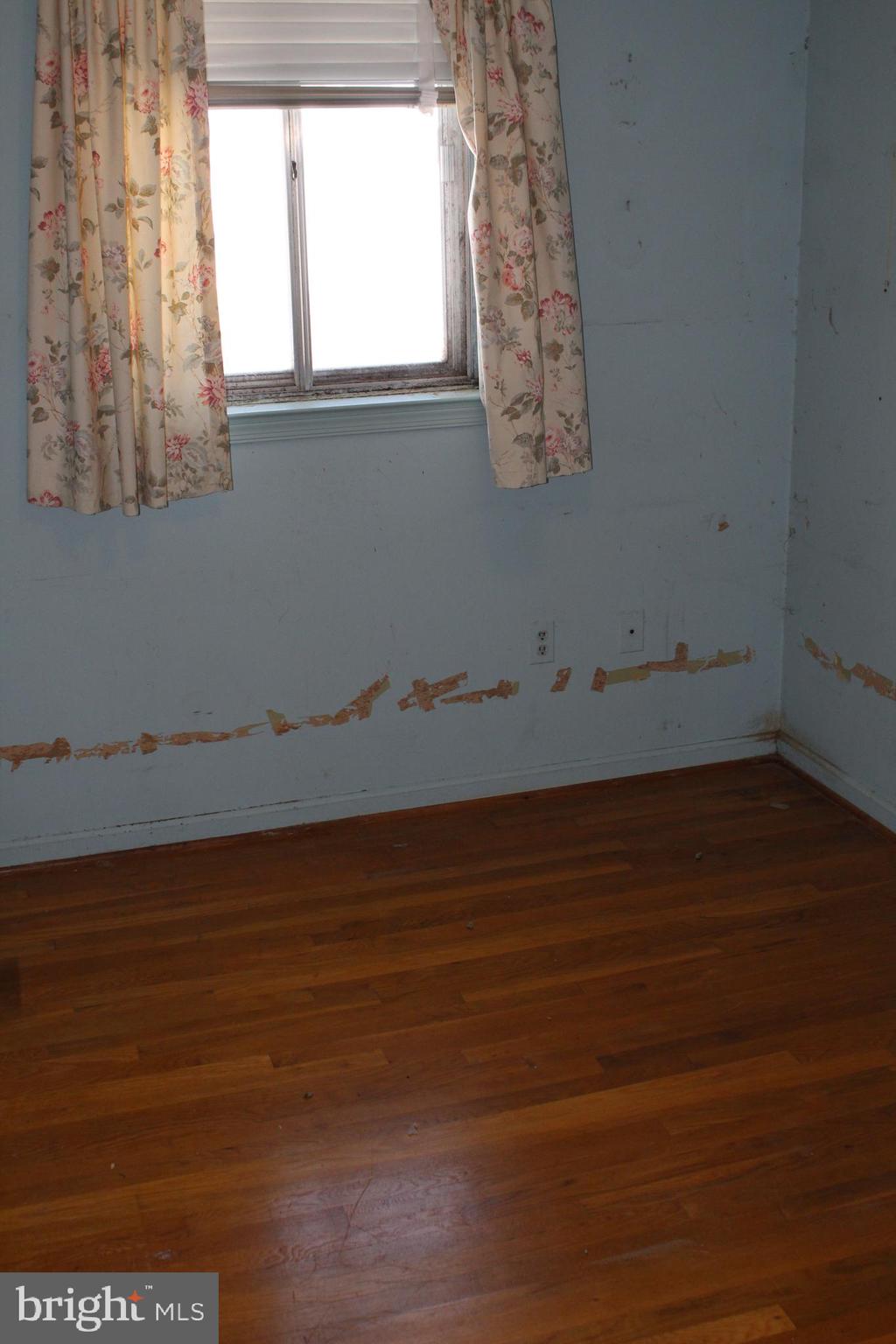 6815 Rolling Road Springfield, VA 22152 - Photo 11 of 22 a view of an empty room with wooden floor and a window