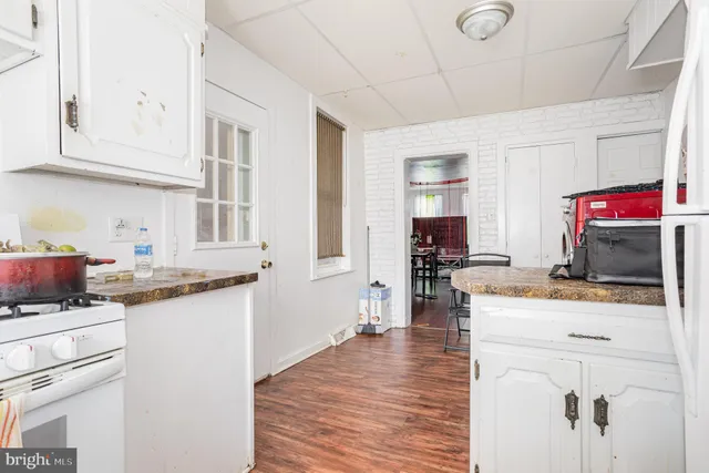 a kitchen with granite countertop a sink stove and cabinets