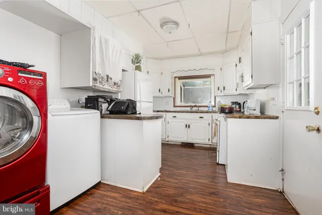 a kitchen with granite countertop a sink cabinets stainless steel appliances and wooden floor