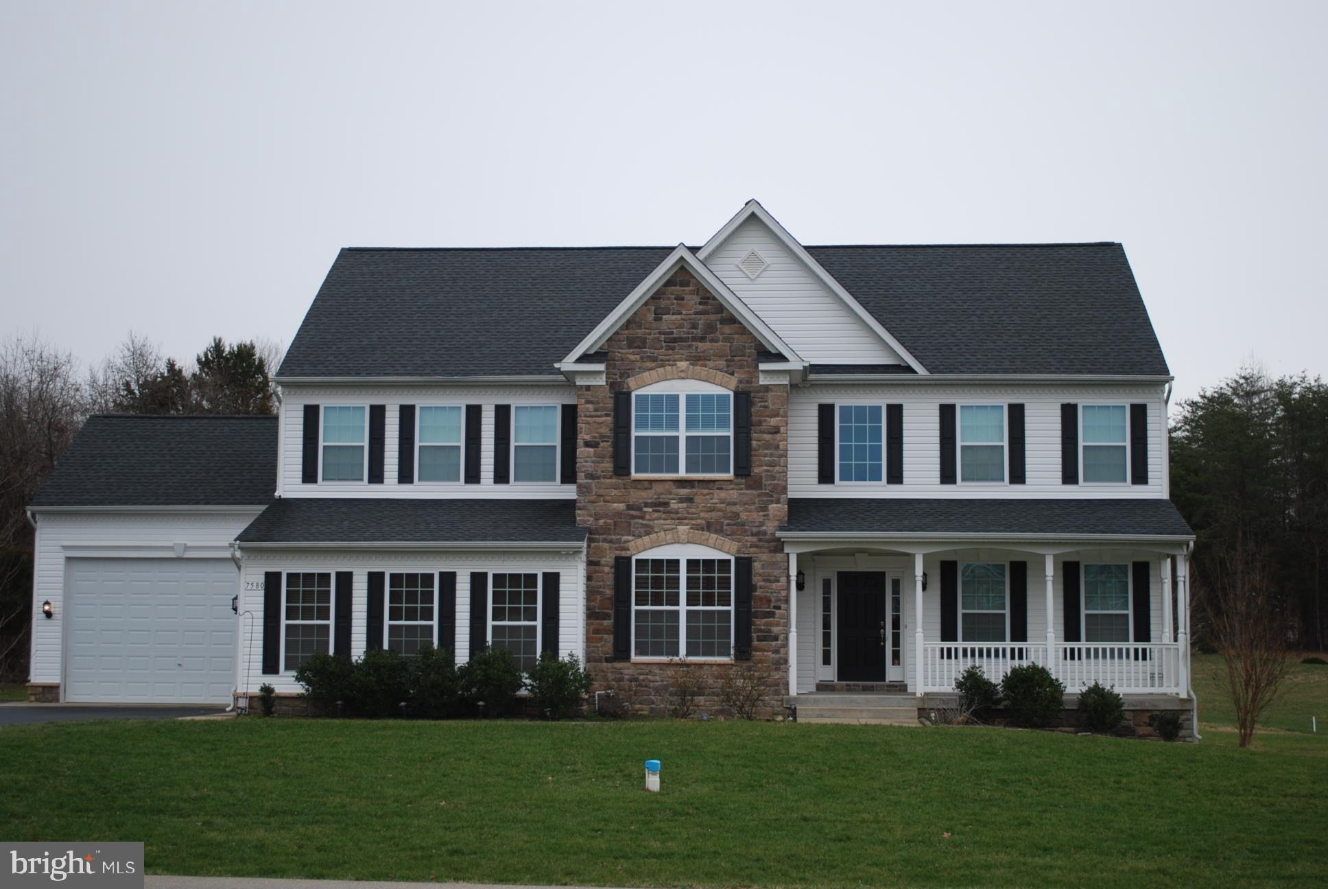 a front view of a house with a garden and plants